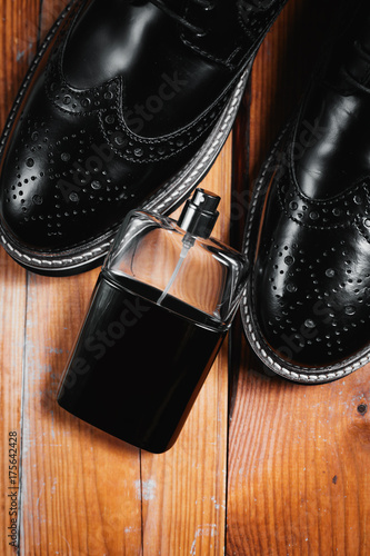 Men shoes and perfume on wooden background