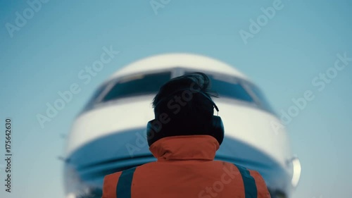  Airport worker signaling to airplane pilot on the runway. photo