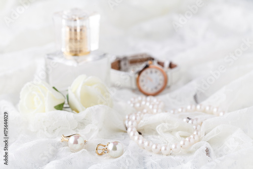 glass scent bottle on ladies dressing table with shabby schic pearl necklace and laces photo