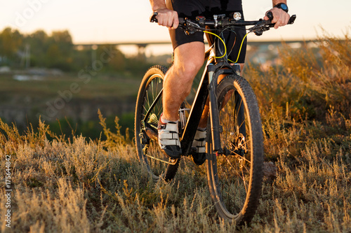 Closeup of cyclist man legs riding mountain bike on outdoor trail