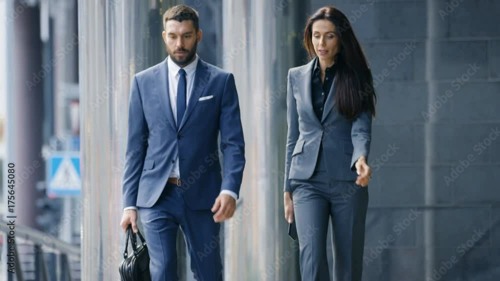 Male and Female Business People Walk and Financial Matters. They're Work in the Central Business District. Shot on RED EPIC-W 8K Helium Cinema Camera. Male and Female Business People Walk and Financial Matters. They're Work in the Central Business District. Shot on RED EPIC-W 8K Helium Cinema Camera.