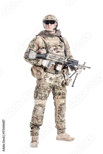 Full length low angle studio shot of big muscular soldier in field uniforms with machine gun  portrait isolated on white background lot of copyspace. Protective goggles glasses are on