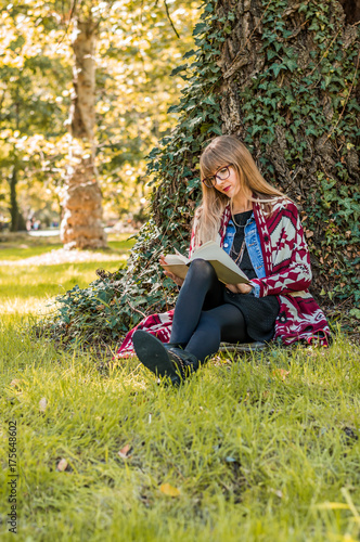 blonde enjoying the book in the park