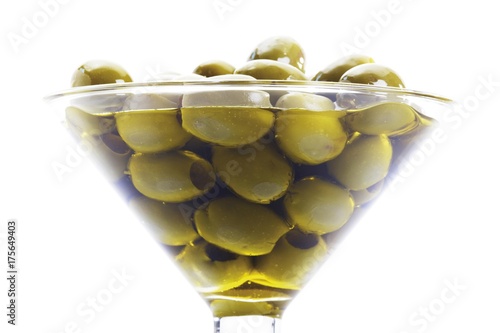 Green olives in a cocktail glass with olive oil photo