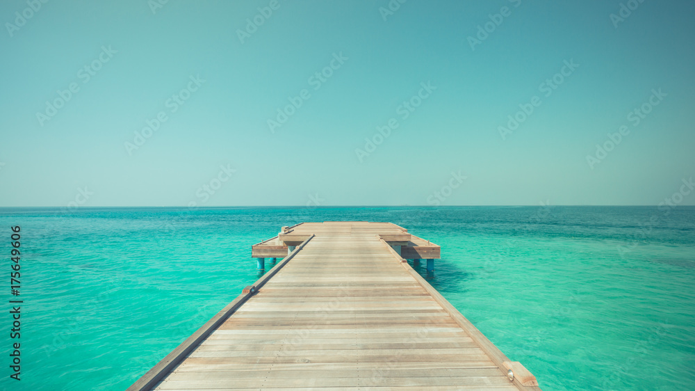 Inspirational beach scene. Endless blue sea and wooden pier