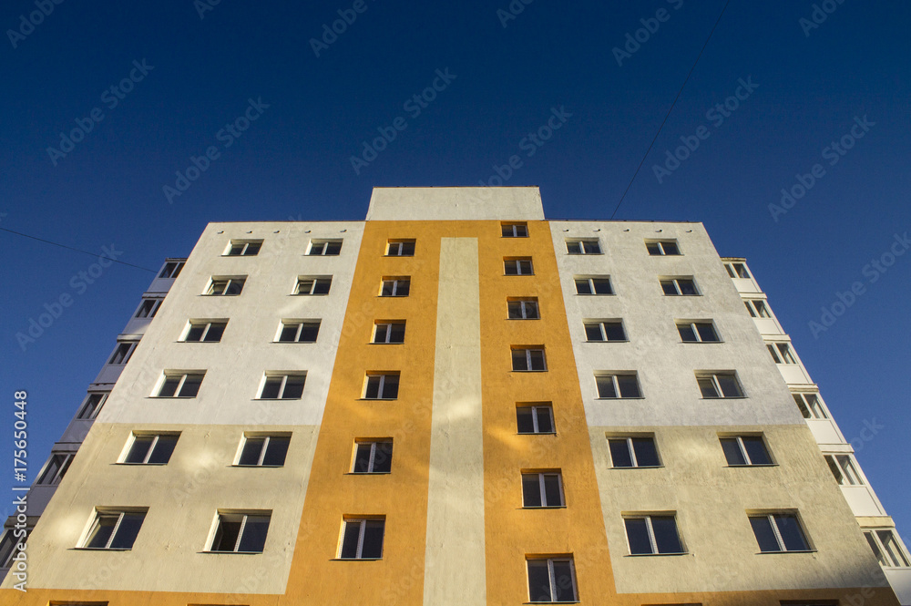 New yellow residential building against the blue sky.