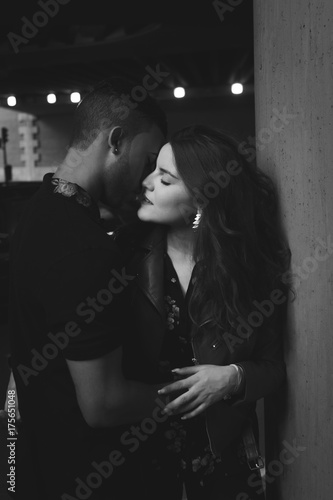 Young male and female couple kissing in the street - black and white