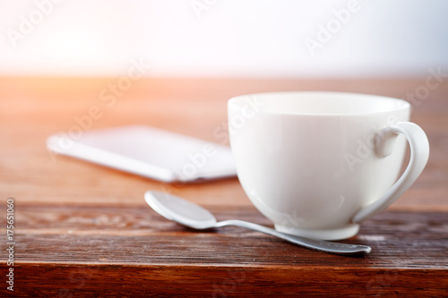 Laptop and cup of tea on rustic wooden table.