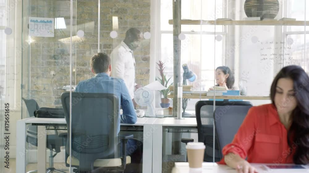 Casual business team in a meeting & man drawing a graph on glass screen Casual business team in a meeting & man drawing a graph on glass screen