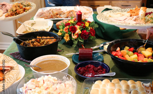Casual Thanksgiving Feast on Table with Plates Being Filled photo