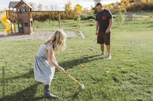Father and daughter playing croquet