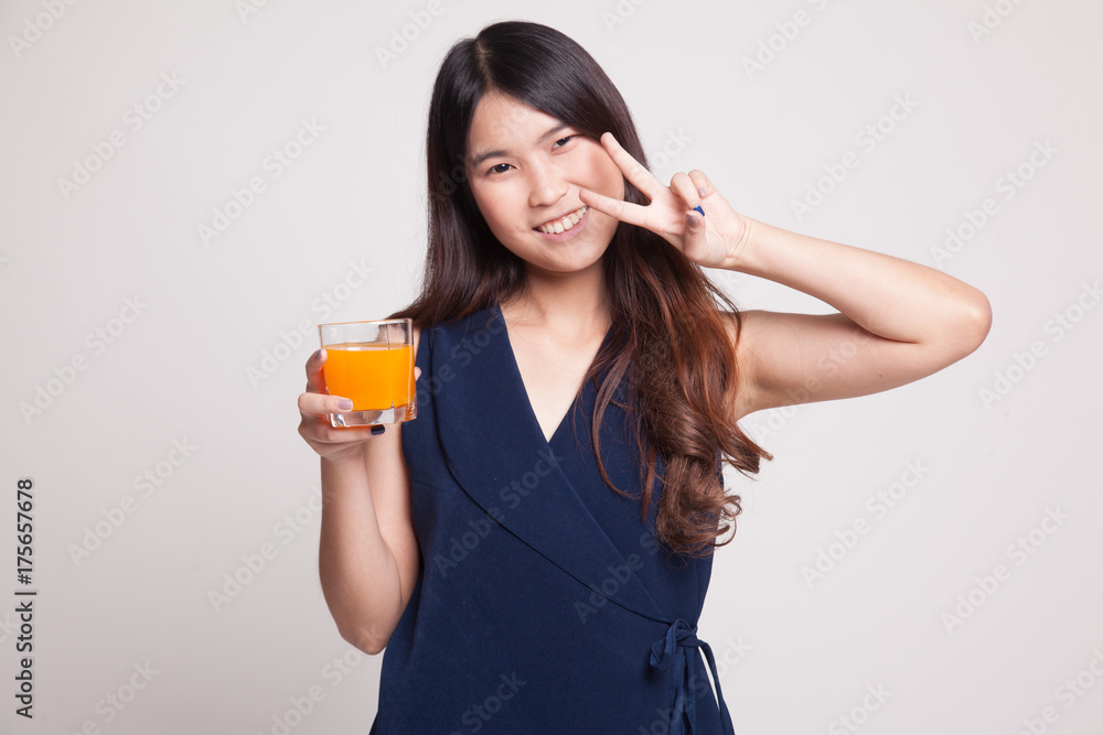 Young Asian woman show victory sign drink orange juice. Young Asian woman show victory sign drink orange juice.