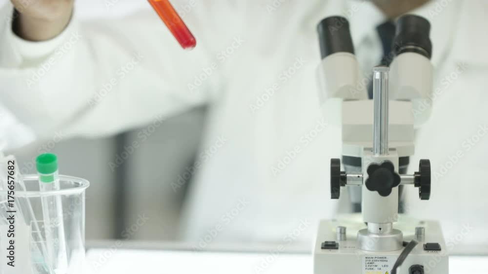 Close up medical researcher working in the lab with microscope & test tubes. Close up medical researcher working in the lab with microscope & test tubes.
