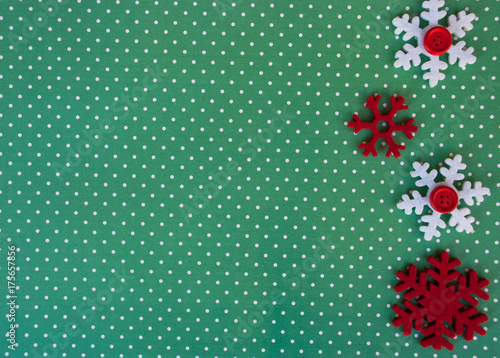 New year background with red snowflakes on green paper with white points. Christmas card idea.Space for text.Xmas blank.