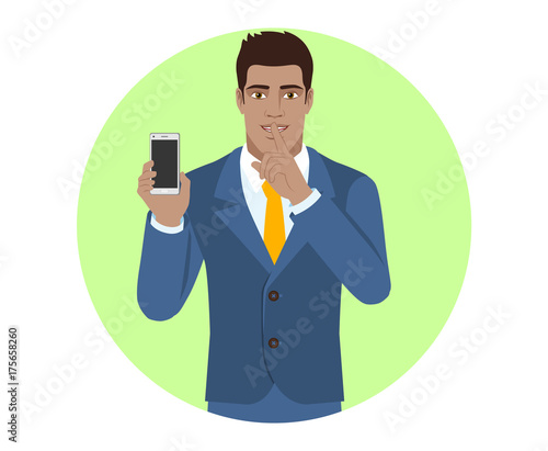 Hush hush. Businessman holding mobile phone and shows hush-hush sign