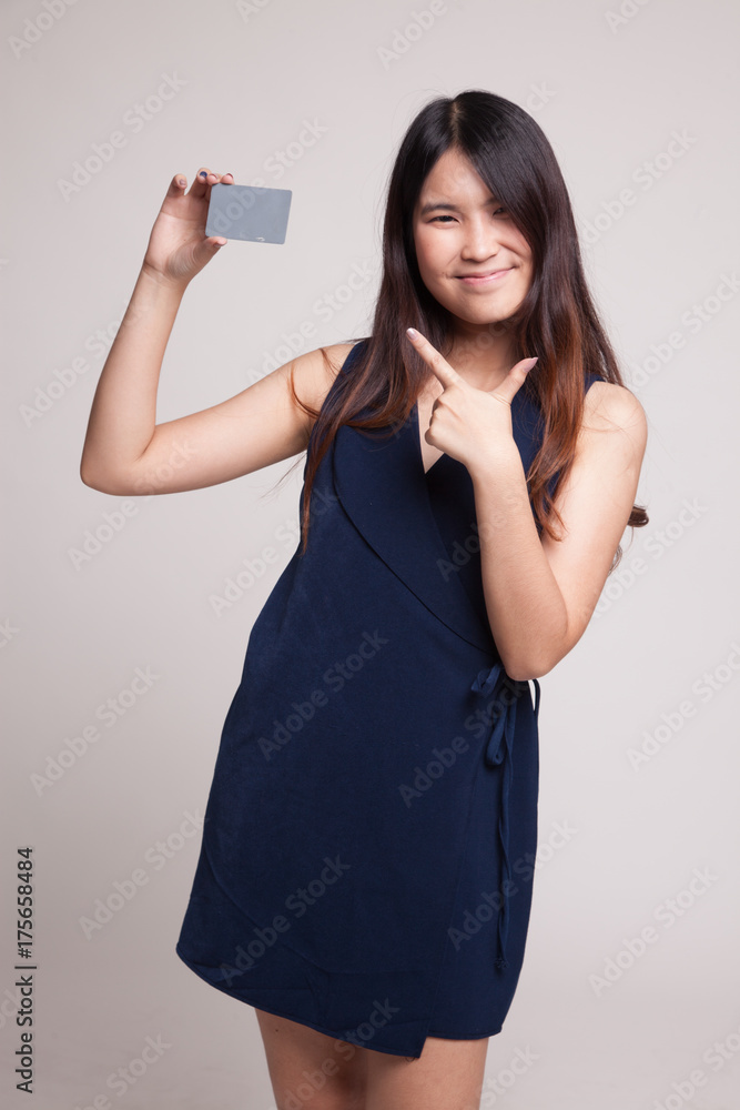 Young Asian woman point to a blank card. Young Asian woman point to a blank card.