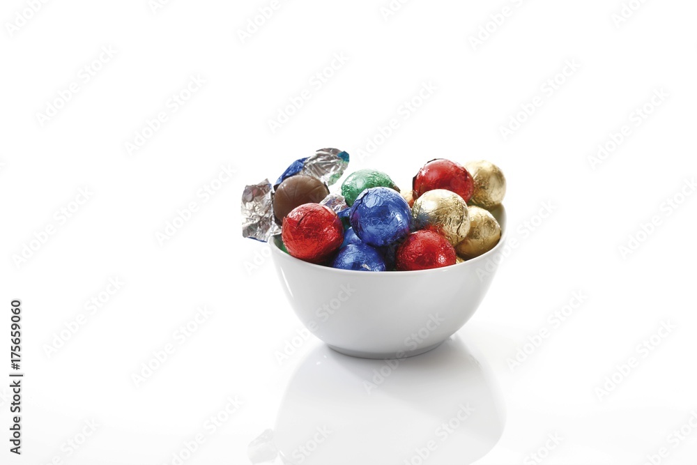 Small porcelain bowl with chocolate balls in coloured wrapping Small porcelain bowl with chocolate balls in coloured wrapping