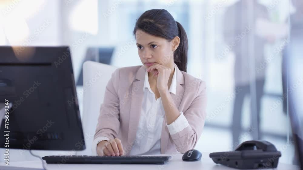  Businesswoman working on computer at her desk in modern office
