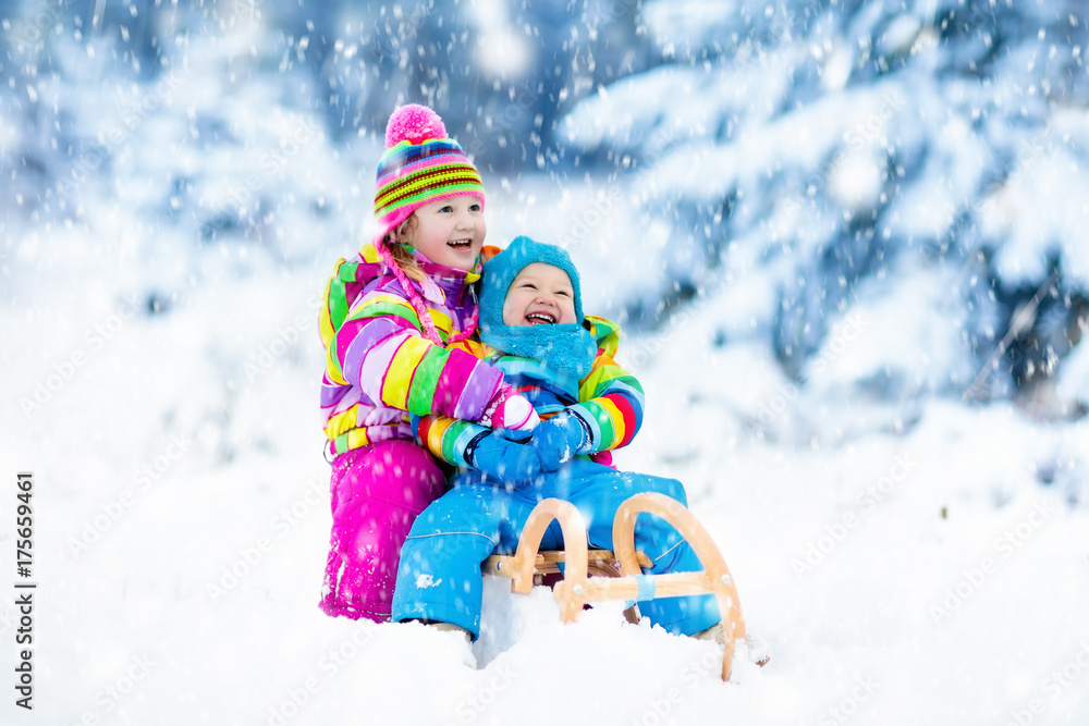 Kids on sleigh ride. Children sledding. Winter snow fun.