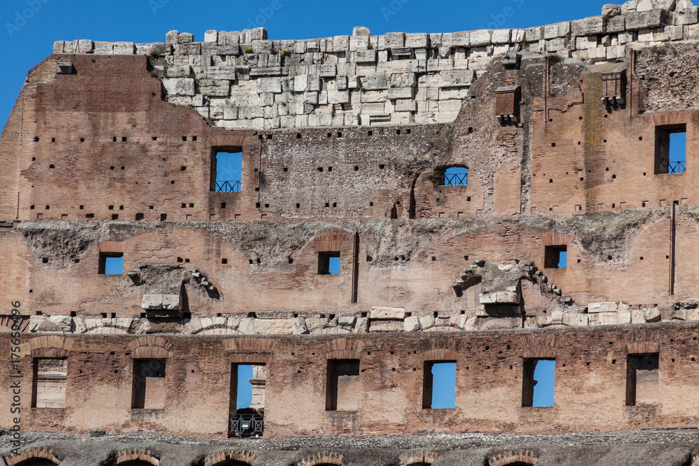 a fragment of Colosseum ruins in Rome with blue sky