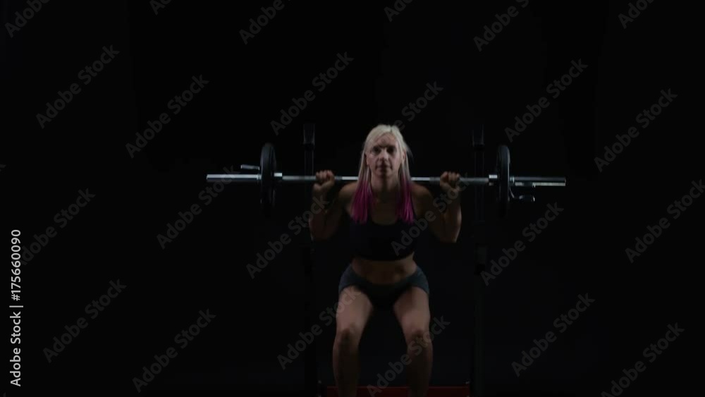 Fit young woman weight training, doing squats with barbell Fit young woman weight training, doing squats with barbell