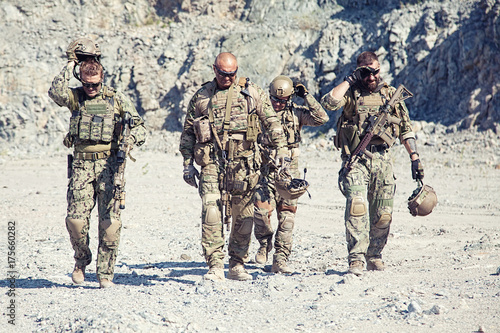 Team squad of special forces in action in the desert among the rocks
