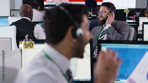  Confident stock market trader doing deals in busy trading room