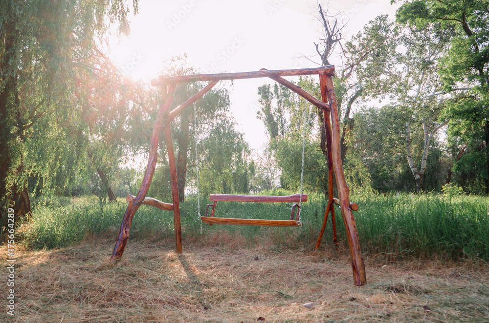 A wooden swing in the park. Eco-friendly materials in green environment