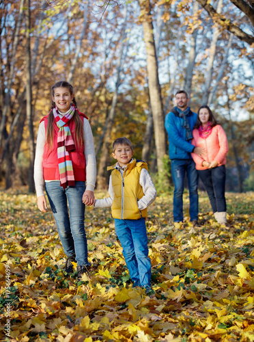 Happy family walking in autumn park