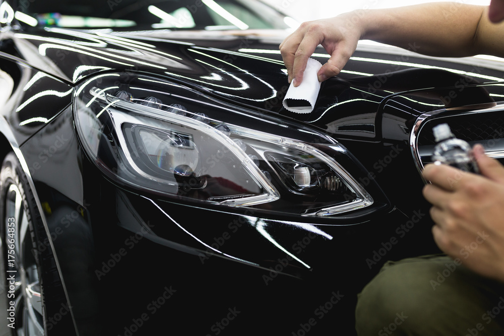 Worker cleaning car - car detailing (or valeting) concept. Selective focus. Worker cleaning car - car detailing (or valeting) concept. Selective focus.