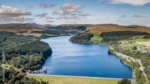 Aerial view of a reservoir and dam wall surrounded by forest photo