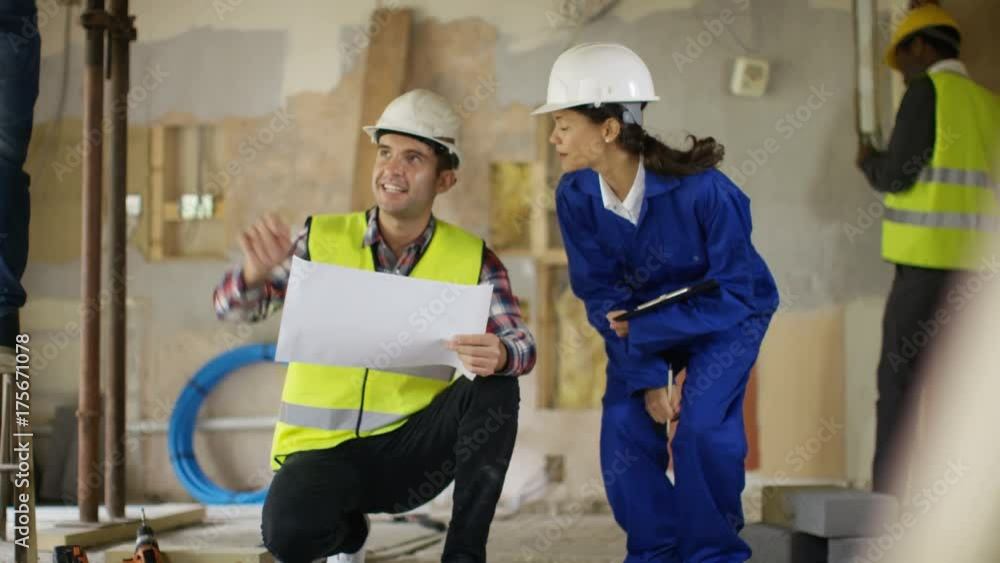 Male architect & female engineer having a discussion at construction site Male architect & female engineer having a discussion at construction site