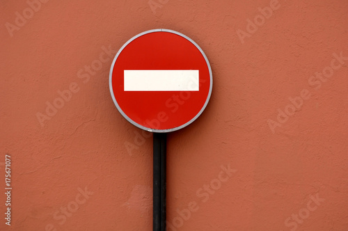 Traffic sign No Entry in front of red wall