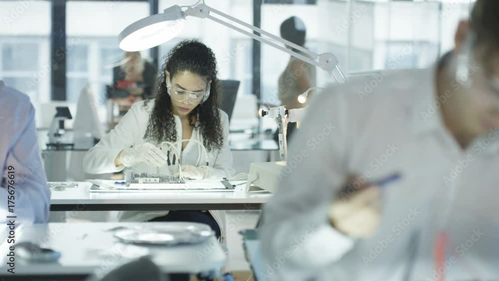Electronics engineers working in lab building & testing motherboards Electronics engineers working in lab building & testing motherboards