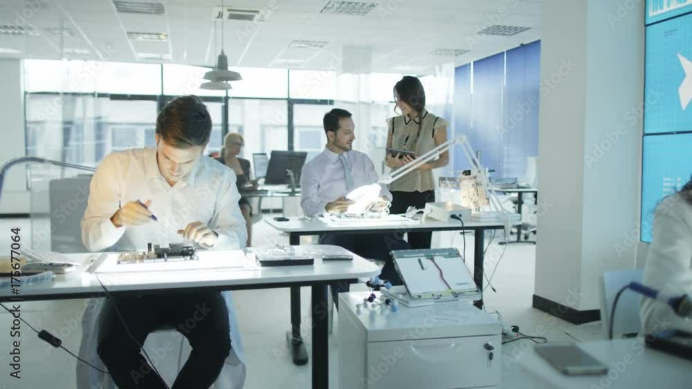 Technicians working in modern lab building electronics & robotics Technicians working in modern lab building electronics & robotics