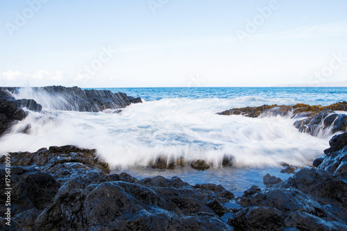 Motion blur of ocean waves crashing on rocks