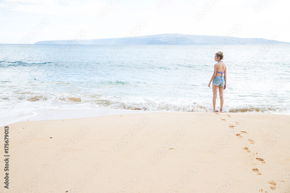 Teenage girl alone at tropical island ocean