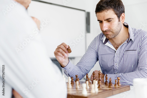 Portrait of two young man playing chess 