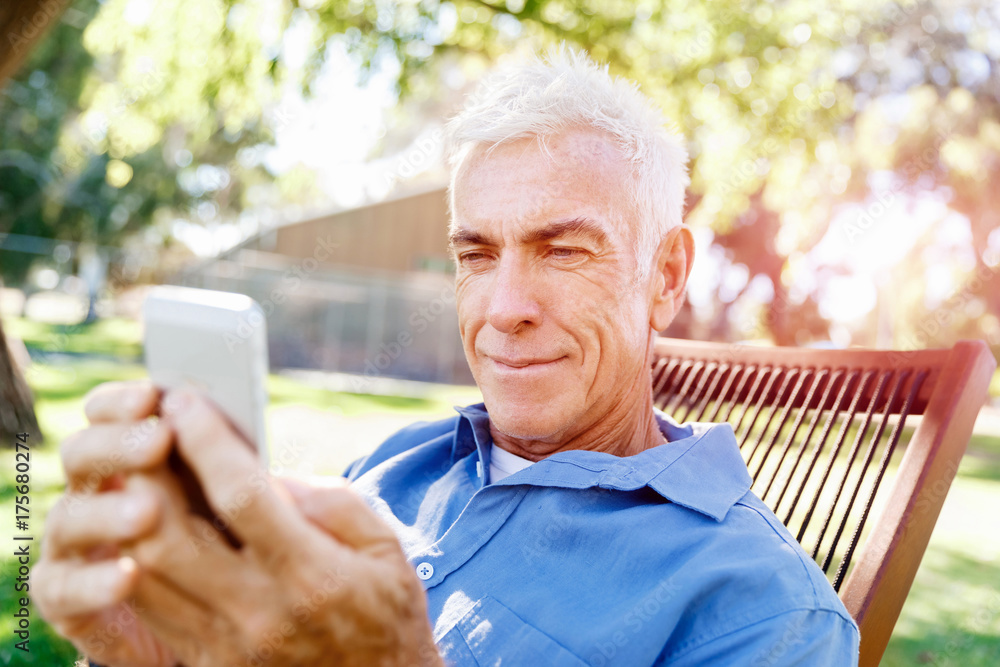 LoMature man outdoors using mobile phone LoMature man outdoors using mobile phone