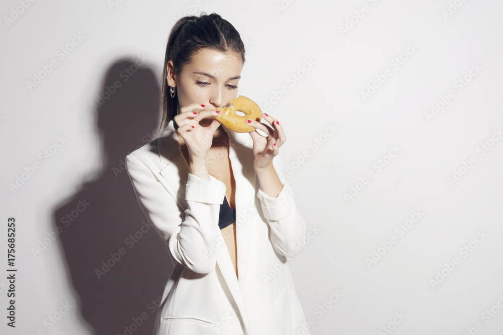 Brunette girl with a classic glase donut. Over a white background. Brunette girl with a classic glase donut. Over a white background.