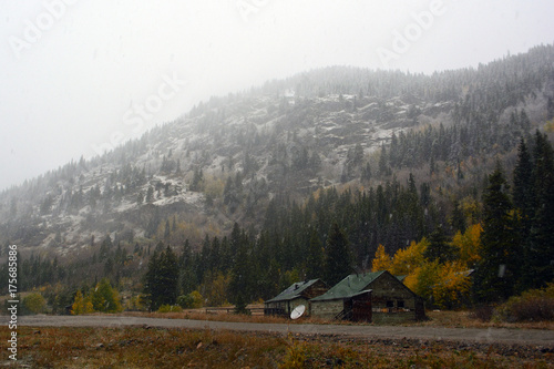 Abandoned Shotgun Shack Home in the Mountains with Snow and Clouds