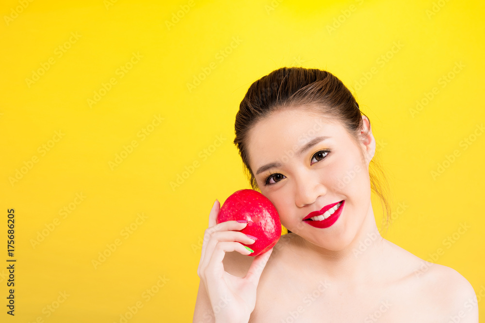 Young Asian woman holding apple isolated in yellow background Young Asian woman holding apple isolated in yellow background