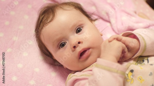 Small baby lies in crib.