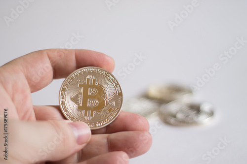 Bitcoins in the hand. A concept from coins of the cryptocurrency on a light background