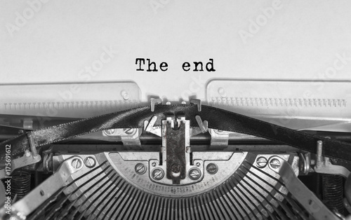 The end inscription in a vintage typewriter. Mechanisms close-up. Entering words into an old typewriter.