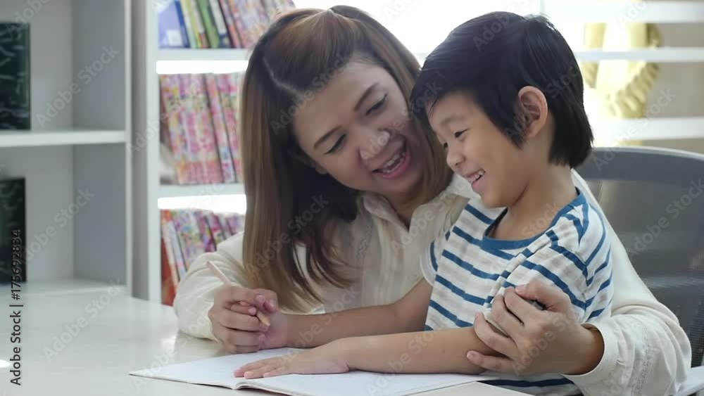 Asian mother helping her son doing homework on white table slow motion Asian mother helping her son doing homework on white table slow motion