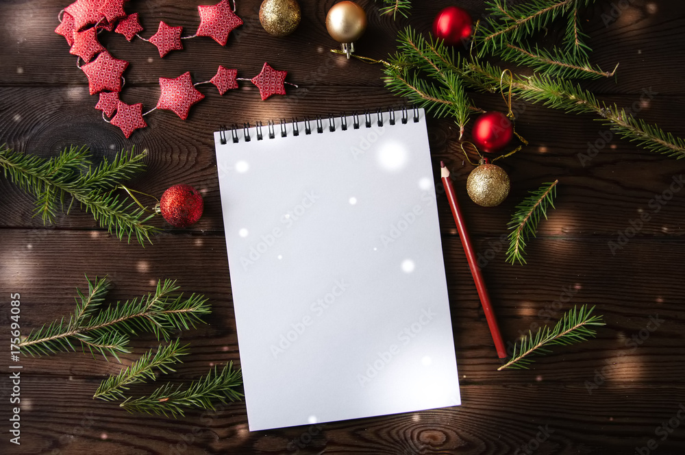 Obraz premium White empty notepad paper with christmas decoration on a wooden background. Flat lay.