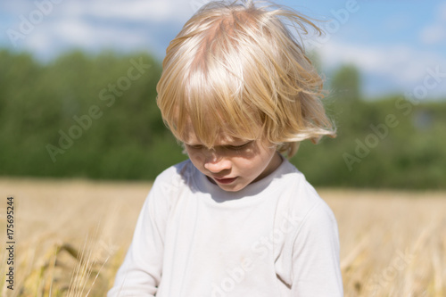 Obraz na płótnie Blond Slavic happy kid boy at a ripe rye wheat field, autumn harvest, Russian forest, the Urals w salonie