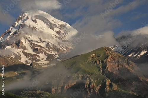 Snow-capped mountains Kazbek at dawn and the valley below where there is a church siete Trinity. Georgia.