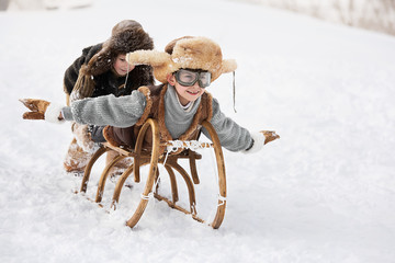 Children slide down hills on sleds